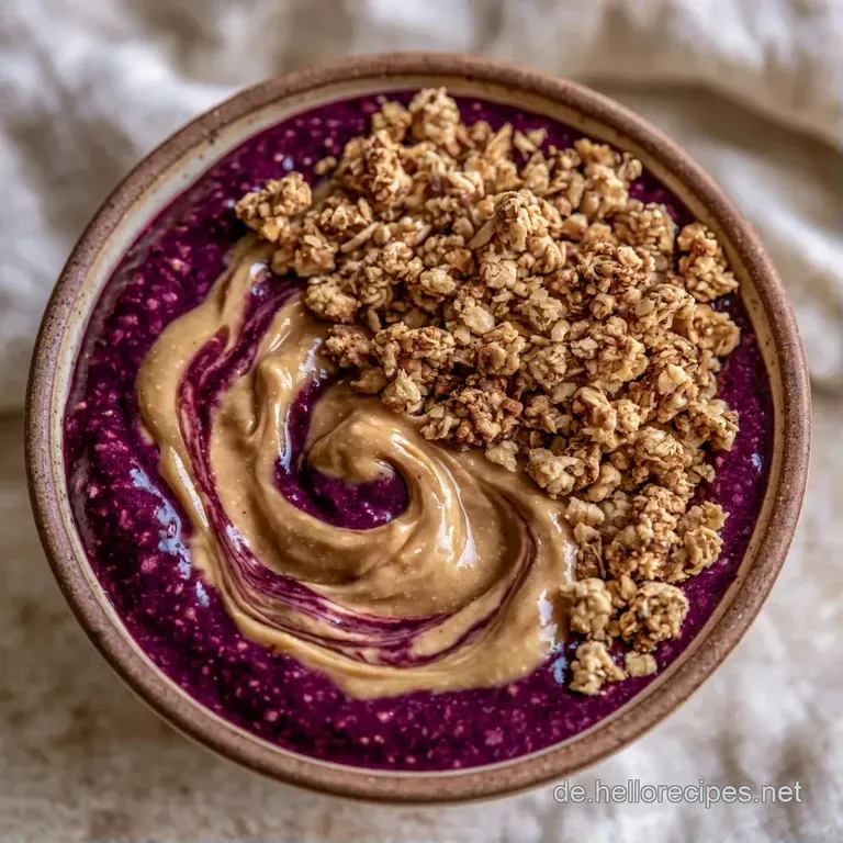 Eine stylische Schale mit dunkelviolettem Smoothie, garniert mit Beeren und N&uuml;ssen auf einem hellen Leinentuch.